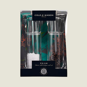 The Cole & Mason UK Prism Salt & Pepper Mill Set Acrylic 165mm features transparent mills with adjustable grind and stainless steel mechanisms, filled with salt crystals and peppercorns, each with a black and green label on top.