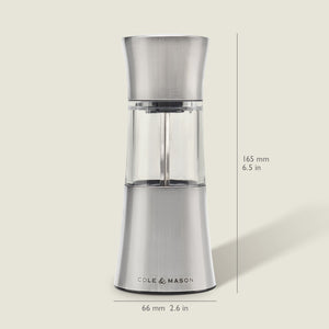 The Cole & Mason Stadhampton Chilli & Spice Mill, made of stainless steel and clear acrylic, stands upright with an ergonomic design, measuring 165 mm high and 66 mm wide. It is shown against a light background.