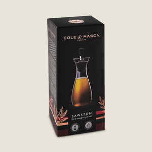 The Cole & Mason Sawston Oil & Vinegar Pourer comes in a sleek black box with gold accents, showcasing the ergonomic pourer filled with liquid on the front and product info on the sides for controlled pouring.
