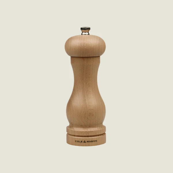 The Beech Capstan Mill Christmas Gift Hamper by Cole & Mason features a wooden pepper grinder with a rounded top, curved body, and metal knob—an elegant touch for any Christmas hamper.