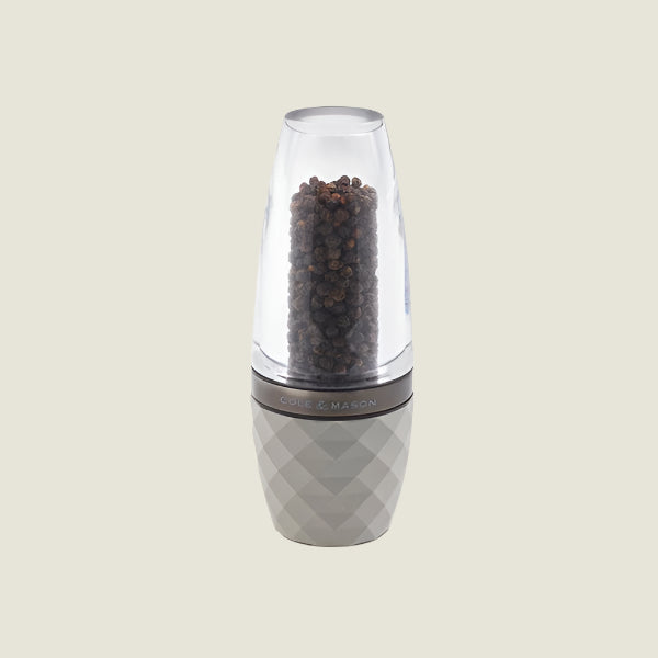The Cole & Mason City Concrete Mill 160mm features a modern design with adjustable grind settings, a clear top filled with salt crystals, and a textured light gray base. It stands upright on a plain, light background.