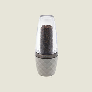 The Cole & Mason City Concrete Mill 160mm features a translucent top displaying black peppercorns, a patterned gray base, contemporary design, and adjustable grind settings, set against a plain light background.