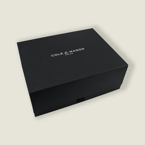 A black rectangular gift box with "Cole & Mason" printed on the lid, perfect for presenting the London Chocolate Wood Mill Christmas Gift Hamper, photographed on a plain light background.