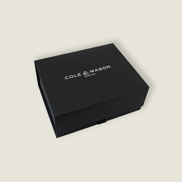 A black rectangular Cole & Mason box with “COLE & MASON ENGLAND” in white on the lid, set against light beige—perfect packaging for the Holborn Mill Christmas Gift Hamper by Cole & Mason.