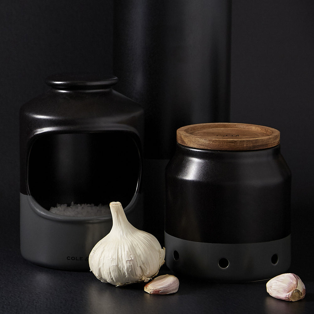 The Cole & Mason Strethall Ceramic Salt Pig features a matte black and grey finish, an open front for easy seasoning control, and the brand name printed near the base, shown against a light background.