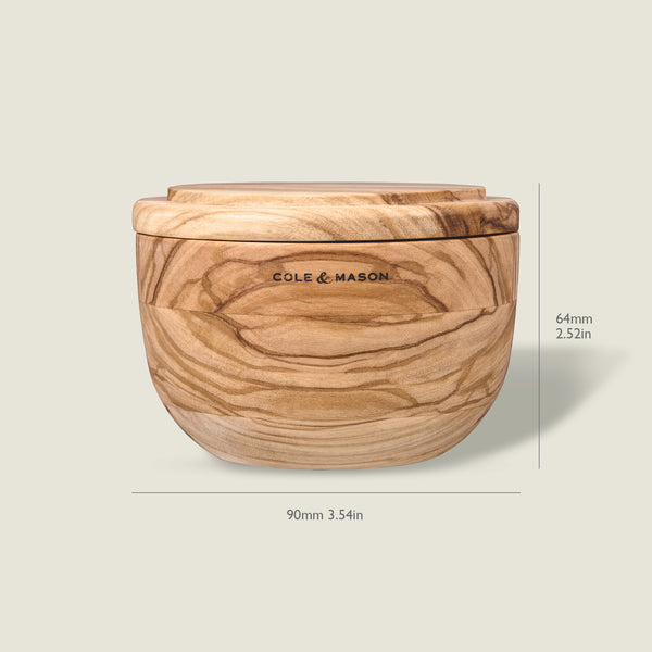 The Cole & Mason Portobello Olive Wood Salt Cellar features a lid and natural swirled grain. Measuring 64mm tall and 90mm wide, this round container adds charm to any kitchen decor.