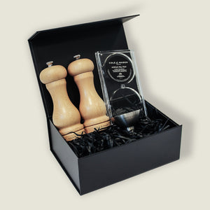 The Cole & Mason Beech Capstan Mill Christmas Gift Hamper features salt and pepper mills, an acrylic salt keeper, metal spoon, and seasonings in a black gift box with shred—perfect for gifting.