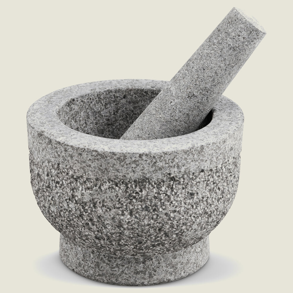 The Cole & Mason Langley Pestle & Mortar, made from natural granite in gray, features the pestle resting inside the mortar and is displayed on a light neutral background—perfect for preparing spice rubs.