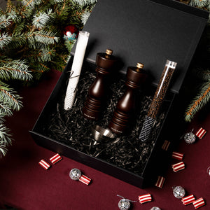 The Cole & Mason London Chocolate Wood Mill Christmas Gift Hamper features two wooden grinders on a burgundy tablecloth with festive decor—ideal for Christmas gift hampers.