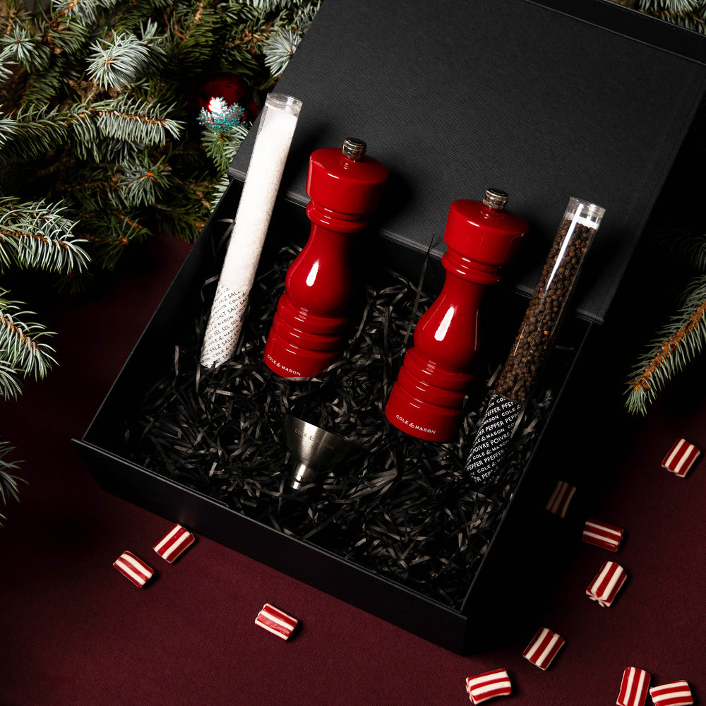 The London Red Gloss Mill Christmas Gift Hamper by Cole & Mason features a stylish salt & pepper mill set, two textured rolls, and a metal funnel in a black gift box with shredded paper—ideal for elegant Christmas gifting.