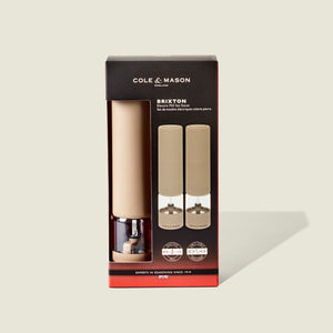 Cole & Mason Brixton Electric Mill Stone GS in beige and clear acrylic, featuring an adjustable grind for customizable seasoning. Presented in a black box with red accents and a clear window showcasing the mills inside.