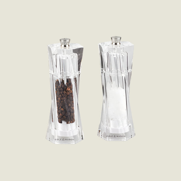 The Cole & Mason Aldeburgh Salt & Pepper Mill Set features two clear acrylic mills with silver tops, a modern faceted design, and premium adjustable grinders for fresh peppercorns or salt crystals.