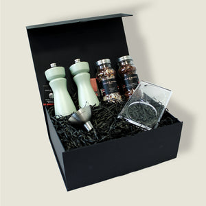 The Kenton Mills in Sage Christmas Gift Hamper by Cole & Mason features two light green mills, an Aromatic Salt & Pepper Refill Set, metal funnel, clear glass, and black shredded paper—ideal for Christmas gifting.