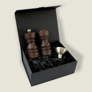 The London Chocolate Wood Mill & Shaker Christmas Gift Hamper by Cole & Mason comes in a black gift box with shredded paper, including a salt shaker, pepper mill, and metal funnel—an ideal Christmas gift for any kitchen enthusiast.