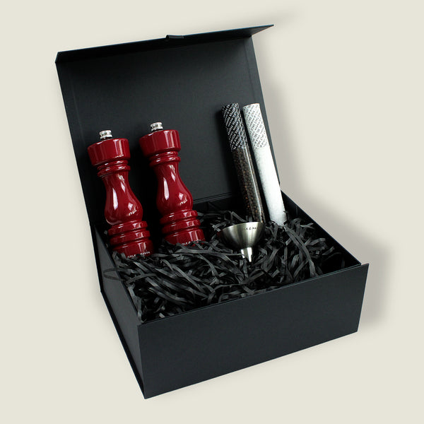 The London Red Gloss Mill Christmas Gift Hamper by Cole & Mason features a stylish salt & pepper mill set, two textured rolls, and a metal funnel in a black gift box with shredded paper—ideal for elegant Christmas gifting.