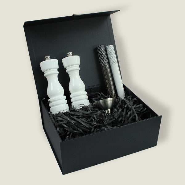 The London White Gloss Mill Christmas Gift Hamper by Cole & Mason is displayed open, revealing a white gloss salt & pepper mill set with ceramic grinders, a metal funnel, and three tubes of spices or salts in an elegant black gift box.