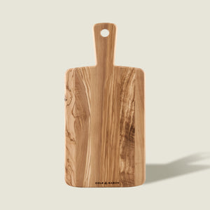 The Cole & Mason Portobello Olive Wood Serving Board is a rectangular Italian board with a handle and rounded edges, showcasing natural grain patterns, a hole in the handle, and the brand name printed at the bottom.
