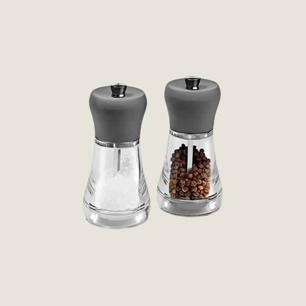 The Cole & Mason Napoli Salt & Pepper Mill Set features elegant grinders with gray tops, high-quality mechanisms, and comes filled with coarse salt and whole black peppercorns on a light background.