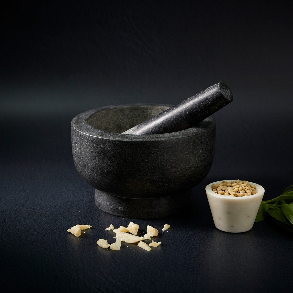 The Cole & Mason Clavering Pestle & Mortar is a dark gray granite set with the pestle inside the bowl—an essential, traditional kitchen tool ideal for home chefs.