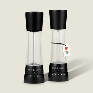 Two Cole & Mason Derwent Matt Black Salt and Pepper Mills stand side by side against a plain light background. One of the mills features a tag reading "reddot winner 2023.