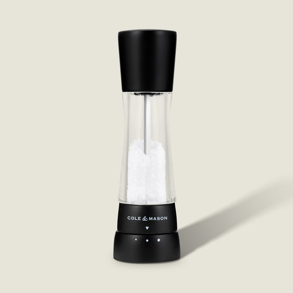 #salt The Cole & Mason Derwent Matt Black Salt & Pepper Mill stands upright on a light background, featuring an acrylic body with a transparent middle, adjustable grind settings, and sleek black top and base.