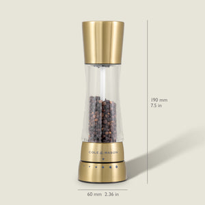 A Cole & Mason Derwent Gold salt & pepper mill stands upright, filled with black peppercorns. Its gold-tone stainless steel body measures 190 mm tall and 60 mm wide, and features advanced grinding technology.