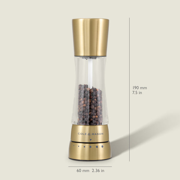 A Cole & Mason Derwent Gold salt & pepper mill stands upright, filled with black peppercorns. Its gold-tone stainless steel body measures 190 mm tall and 60 mm wide, and features advanced grinding technology.