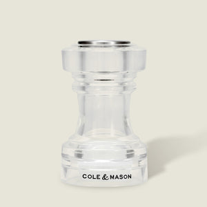 This simple, modern Acrylic Salt Shaker & Pepper Mill Set (104 mm) by Cole & Mason features a clear acrylic adjustable grinder, with the brand name displayed in black on the base against a light beige background.