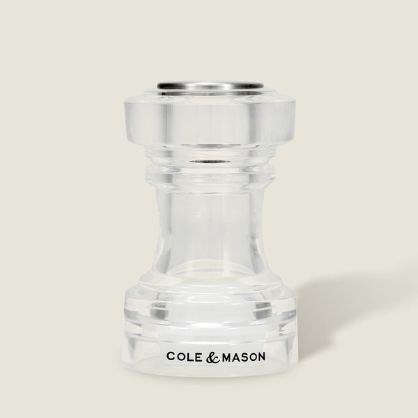 This simple, modern Acrylic Salt Shaker & Pepper Mill Set (104 mm) by Cole & Mason features a clear acrylic adjustable grinder, with the brand name displayed in black on the base against a light beige background.