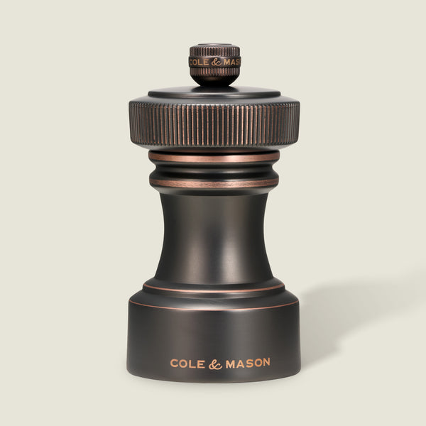 Set against a light background, the Hoxton Salt and Pepper Mill Set in antique bronze from Cole & Mason showcases refined craftsmanship, with “COLE & MASON” engraved on the base. Elegantly presented in a gift box, this striking set is a sophisticated addition to any table.