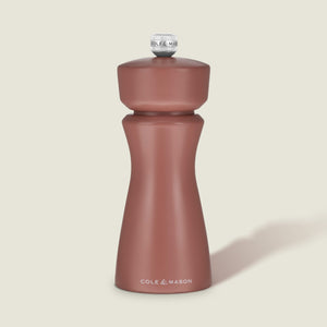 A matte, cinnamon-colored salt and pepper mill with a rounded top and curved body, featuring COLE & MASON in white text at the base, set against a plain, light background. The Kenton Salt & Pepper Mill by Cole & Mason is a stylish kitchen accessory equipped with a durable ceramic grinder for efficient seasoning.