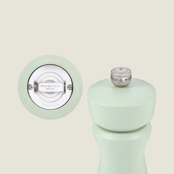 The Kenton Salt & Pepper Mill in Sage by Cole & Mason stands upright, showing a ceramic base mechanism and brand logo. The customizable mill features a top metal knob marked with a P.