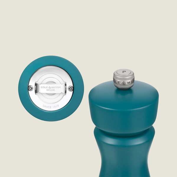 The Cole & Mason Kenton Salt & Pepper Mill in Sea Salt stands upright displaying its ceramic mechanism and branded base. A silver knob marked with a "P" tops the mill, making it ideal for modern kitchens.