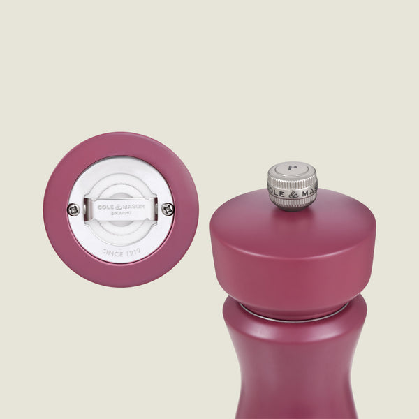 The Cole & Mason Kenton Salt & Pepper Mill in Sichuan Pepper is showcased upright, featuring a matte purple finish and a close-up of its base displaying the ceramic mechanism and branding.