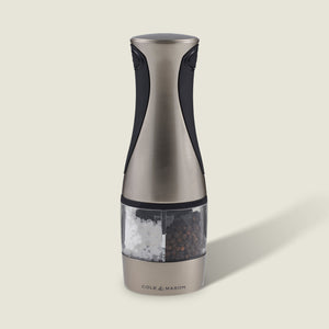 The Cole & Mason Kew Electronic 2-in-1 Duo Mill, a stainless steel and black electric grinder with a clear center for salt and pepper, features adjustable grind settings and stands upright against a light background.
