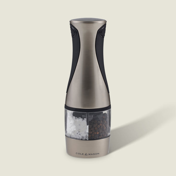The Cole & Mason Kew Electronic 2-in-1 Duo Mill, a stainless steel and black electric grinder with a clear center for salt and pepper, features adjustable grind settings and stands upright against a light background.