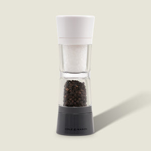 The Cole & Mason Lincoln 2-in-1 Duo Mill grinder has adjustable settings, a white top for salt, and a black base for peppercorns, shown against a light background.