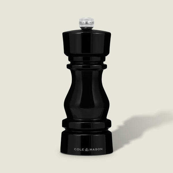 The Cole & Mason London Black Acrylic Salt & Pepper Mill 150mm features a glossy black finish, silver top knob, premium grinding technology, and Cole & Mason branding at the base, shown upright against a plain light background.