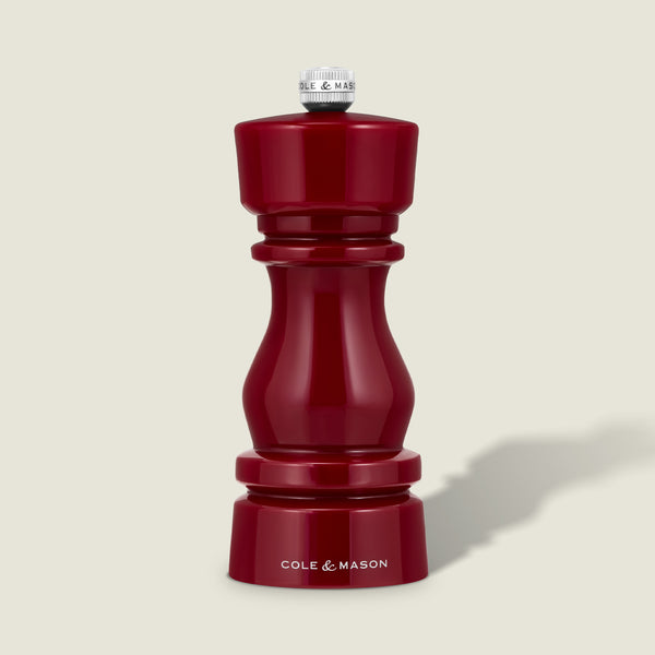 The Cole & Mason London Red Acrylic Salt & Pepper Mill (150mm) features a glossy red finish with a silver knob on top and "Cole & Mason" displayed in white at the base. It comes with an adjustable grinding mechanism for precise seasoning, showcased against a plain light background.