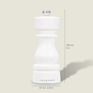 The Cole & Mason London White Acrylic Salt & Pepper Mill, measuring 150mm (6 in) tall and 57mm (2.24 in) wide, features an adjustable grinder—perfect for modern kitchens. Pictured upright on a light beige background.