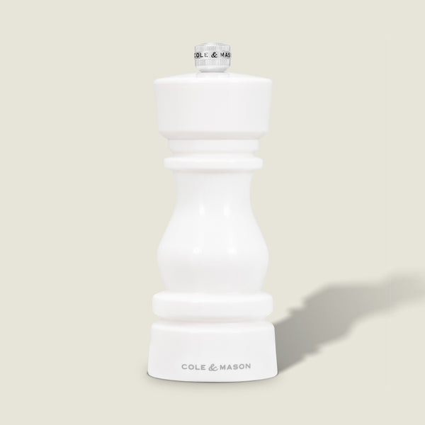 The Cole & Mason London White Acrylic Salt & Pepper Mill (150mm) features a modern, curved design, adjustable grind, and brand logo at the base—perfect for contemporary kitchens. It stands upright on a light gray background with a subtle shadow.
