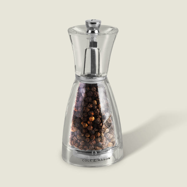 #pepper
The Cole & Mason Pina Salt & Pepper Mill, with a clear acrylic design, whole black peppercorns, and a silver top labeled at the base, delivers high-performance grinding against a pale background.