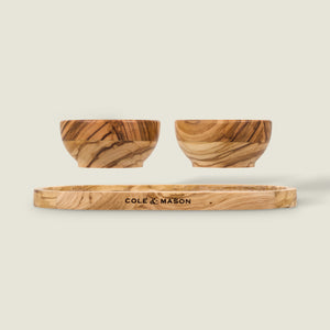 The Cole & Mason Portobello Olive Wood Pinch Pot Set includes two small olive wood pinch pots and a matching seasoning tray, all engraved with the brand name and set against a plain, light background.