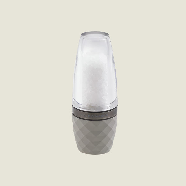 The Cole & Mason City Concrete Mill 160mm features a modern design with adjustable grind settings, a clear top filled with salt crystals, and a textured light gray base. It stands upright on a plain, light background.